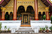 Luang Prabang, Laos - Wat Xieng Mouan with the faade decorated with brightly painted Jataka tales. 